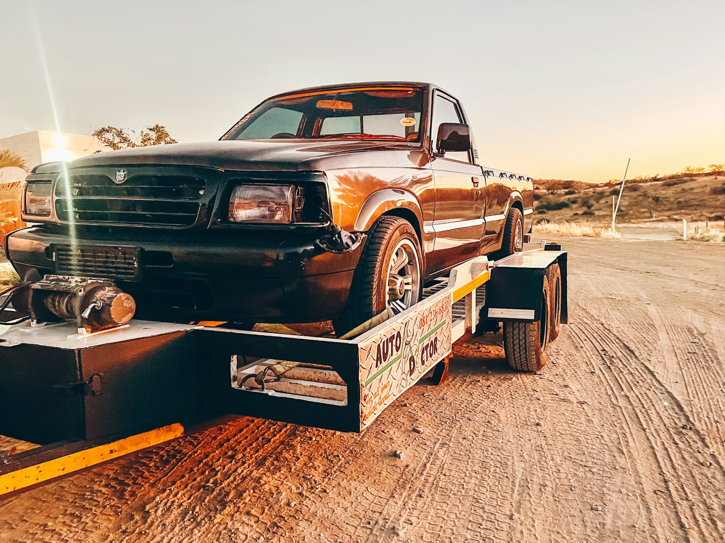 Professional towing service - truck being towed on flatbed trailer